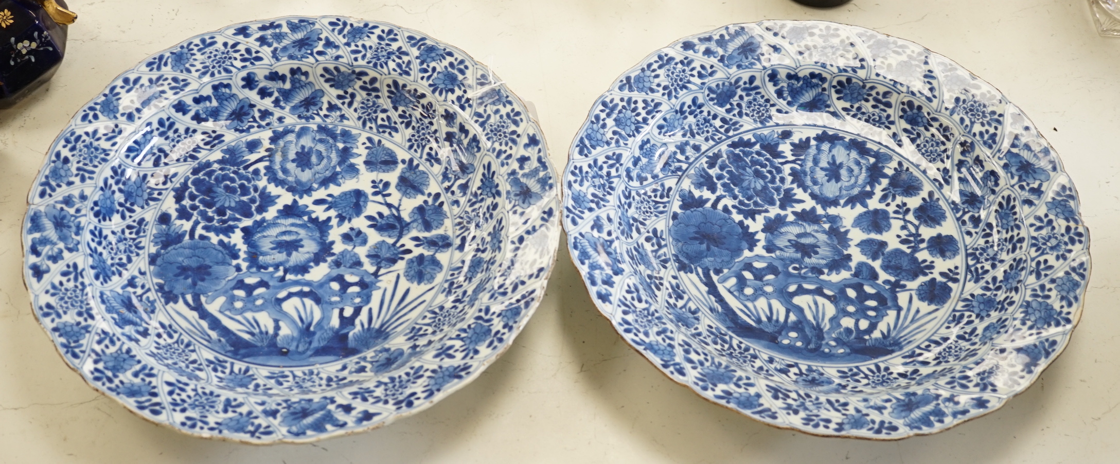 A pair of Chinese Kangxi blue and white dishes, painted with rock work and flowers, artemisia leaf marks, 37cm diameter